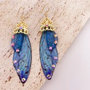 Close-up detail of vintage blue cicada wing earrings with colorful rhinestones and gold accents
