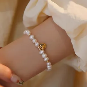 Bracelet élégant en perles d'eau douce avec un charmant cœur en or poli au poignet