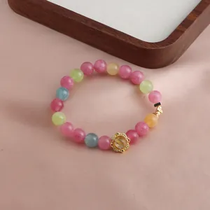Detaillierte Ansicht eines mehrfarbigen Kristallarmbands mit goldenem Lotusanhänger