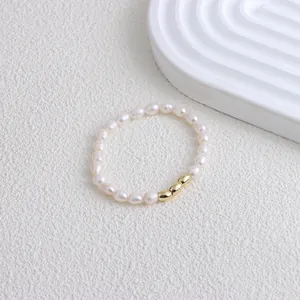 Exquisite detail shot of a handmade freshwater pearl bracelet with three polished gold beads