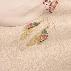 Detailed close-up of ethereal cicada wing earrings with sparkling crystal accents