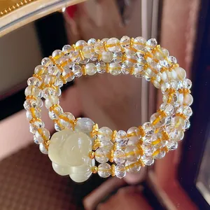 Close-up of double-strand yellow crystal bracelet with moonstone and carved cat