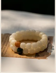 Vue détaillée d'un bracelet en graines de Bodhi blanches avec perles sur papier vintage