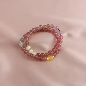 Detail of a double-loop strawberry quartz bracelet with colorful gemstone accents