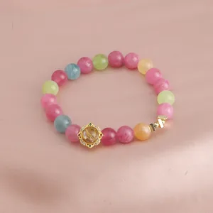 Detail eines bunten Kristall-Armbands mit kunstvollem Blumenanhänger
