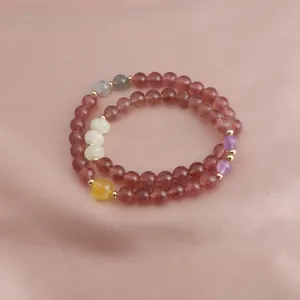 Detail view of double-strand strawberry quartz bracelet with Alashan and amethyst beads.