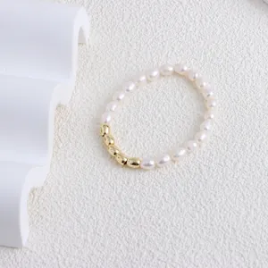 Close-up of a minimalist freshwater pearl bracelet featuring five elegant gold metallic beans