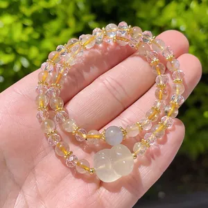 Close-up of double-strand natural citrine bracelet with moonstone and carved cat pendant