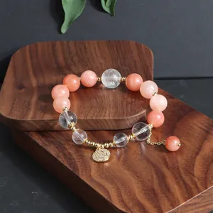 Detailansicht eines Naturkristall-Perlenarmbands mit einem goldenen Smiley-Anhänger