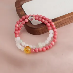 Macro detail view of a double-strand beaded bracelet with pink stones and citrine