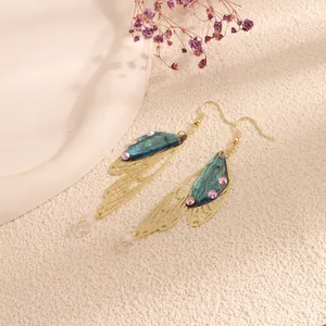 Elegant gold-tone butterfly wing dangle earrings with blue translucent wings and crystals