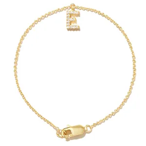 Close-up of a gold-plated chain bracelet featuring a zircon-encrusted letter E pendant