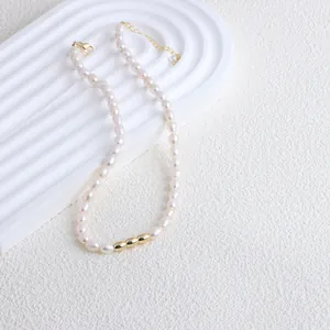 Detail view of an elegant freshwater pearl necklace with three gold bean-shaped beads