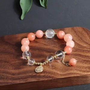 Nahaufnahme des Perlenarmbands aus Sonnenstein und Kristall mit glitzerndem Smiley-Anhänger