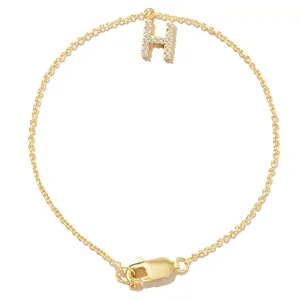 Detailed view of a gold-plated bracelet with a sparkling pavé zircon initial H pendant