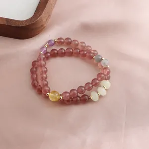 Macro detail of double-loop beaded bracelet featuring strawberry quartz, sunstone, and amethyst beads
