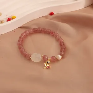 Close-up of strawberry quartz bracelet with moonstone cat paw and freshwater pearl detail