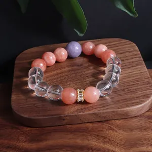 Detailansicht eines handgefertigten Edelsteinarmbands mit Sonnenstein auf Holz