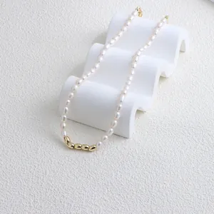 Close-up of freshwater pearl necklace with gold bean accents on a white display stand