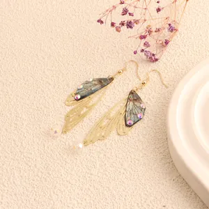 Detailed view of long cicada wing earrings with gold hollow frames and iridescent accents