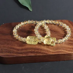 Macro detail of natural yellow crystal bracelets with delicate carved fox and plaque charms