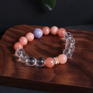 Detaillierte Nahaufnahme eines mehrfarbigen Edelsteinarmbands auf einem Holztablett
