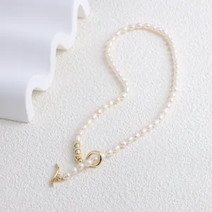 Detail of freshwater pearl necklace with golden bean beads and elegant OT clasp closure