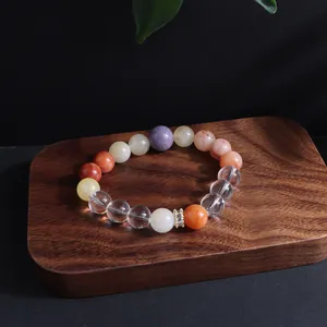 Detailansicht eines bunten Kristallperlen-Armbands auf einem dunklen Holzsockel