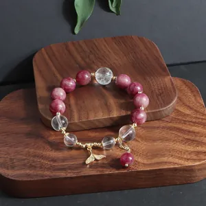 Detailansicht des handgefertigten Armbands aus rosa Turmalin und Bergkristall mit Goldfischschwanz.