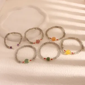 Macro detail of various stone bracelets with moonstone, citrine, and pumpkin beads