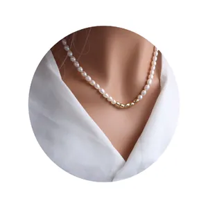Elegant freshwater pearl necklace with golden bean accents on white shirt.