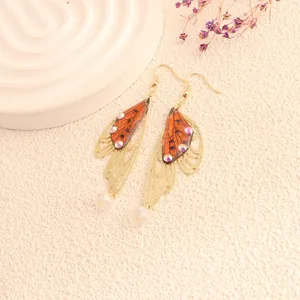 Elegant butterfly wing drop earrings with gold finish and iridescent rhinestone accents
