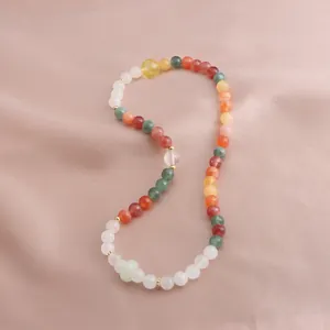 Detailed view of colorful mixed stone beaded bracelet on elegant pink silk background