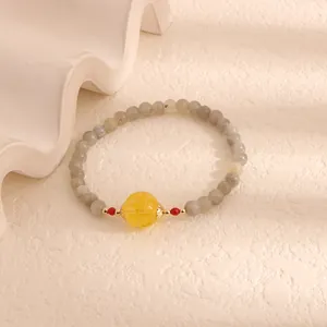 Detail of moonstone beaded bracelet with yellow citrine focal bead and gold accents