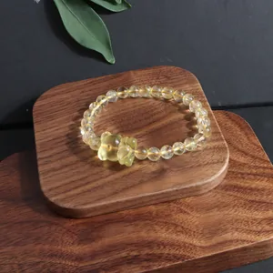 Natural yellow citrine beaded bracelet with carved nine-tailed fox charm on wood display