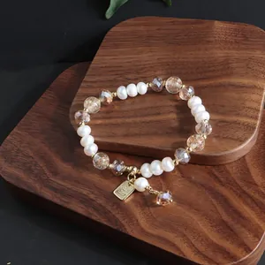 Detailansicht eines Armbands aus Süßwasserperlen und Kristall auf einem Holzdisplay