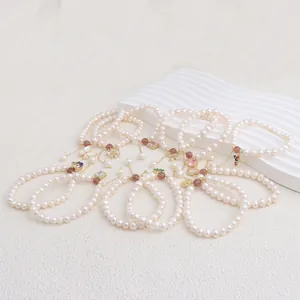 Close-up detail of natural freshwater pearl bracelets with various heart and bee charms