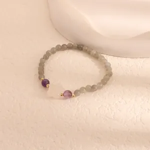 Detailed view of labradorite beaded bracelet with amethyst and white jade flower charm