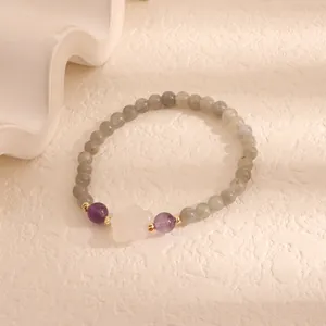 Detailed view of labradorite bead bracelet with purple amethyst and white flower charm.