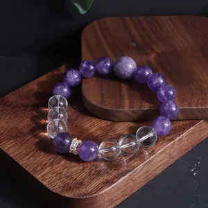 Elegantes Detail des Amethyst- und Bergkristall-Armbands auf einem Holzständer