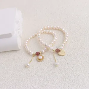 Detailed macro view of natural freshwater pearl bracelets with gold heart charms