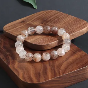 Primer plano detallado de pulsera de cuentas de cristal natural Super Seven sobre madera