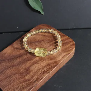 Detailed macro shot of natural citrine lemon crystal bracelet on a wood surface