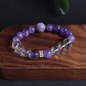 Detailansicht eines Amethyst-Perlenarmbands auf einem dunklen Holzsockel.