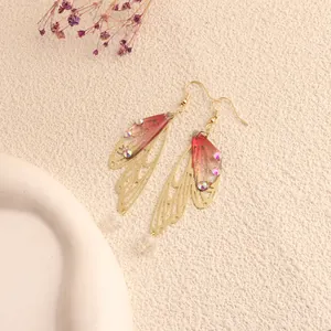 Detailed view of delicate cicada wing earrings with colorful rhinestones