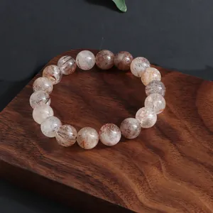 Vista detallada de una pulsera de cristal Super Seven natural en soporte de madera