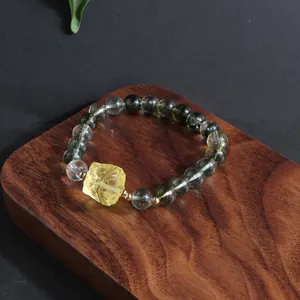 Close-up of New Chinese style green phantom quartz bracelet with yellow carved centerpiece