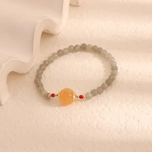 Detailed macro view of moonstone bracelet with central orange pumpkin chalcedony bead