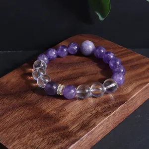 Detailansicht eines Amethyst- und Quarzkristall-Perlenarmbands auf Holzblock
