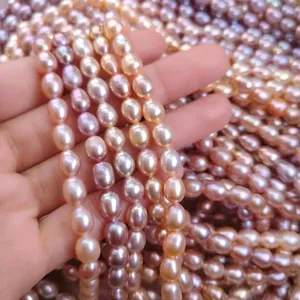 Detalle de hilos de perlas de agua dulce brillantes en forma de arroz rosas y lilas.